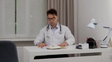 a male doctor reviews x-rays and test results and rewrites them by hand in a notebook to identify the optimal treatment plan
