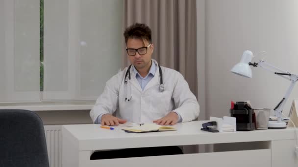 Mężczyzna Lekarz Przegląda Rentgenowskie Wyniki Badań Przepisuje Ręcznie Notebooku Celu — Wideo stockowe