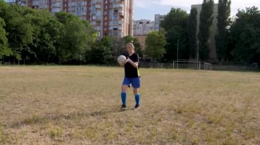 soccer players girl kicks the ball with her knee and runs after it