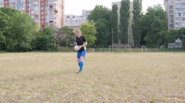 the girl puts the ball for a free kick, runs up and hits the ball towards the camera
