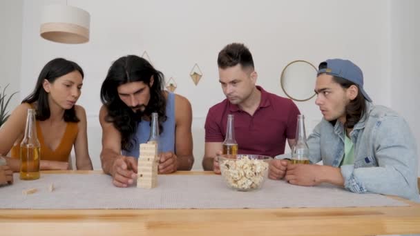 Group Friends Watch Intently Guy Puts His Wand Game Jenga — Stock Video