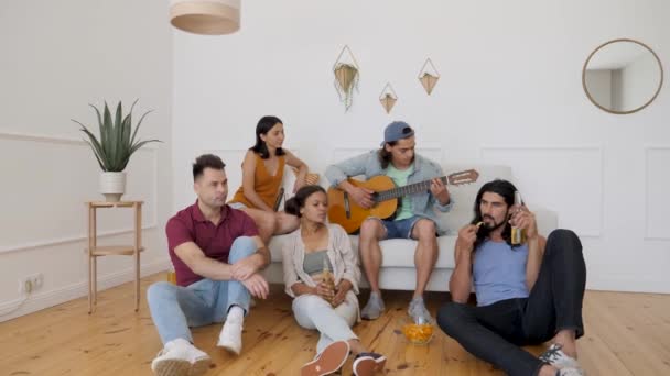Guy Plays Guitar His Friends Sitting Couch — Vídeo de stock