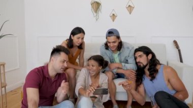 a dark-skinned girl shows her friends a video on her phone and the whole company discusses it
