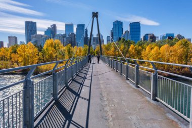 Calgary, Alberta, Kanada - 27 Eylül 2021: Sunnyside ile Prince 's Island arasındaki Bow River Pathway, arka planda Calgary silueti