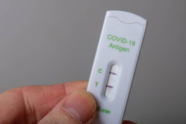 Elinde bir Covid-19 antijen hızlı testi var.
