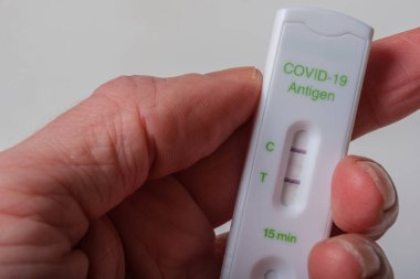 Elinde bir Covid-19 antijen hızlı testi var.