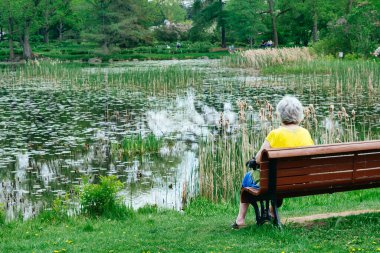 Montreal, CA - 16 May 2022: Senior woman sitting on a bench in Montreal Botanical Garden