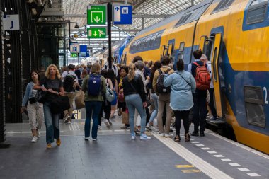 Amsterdam, Hollanda - 21 Haziran 2022: Amsterdam Merkez İstasyonu 'ndan Nederlandse Spoorwegen Treni' ne binen insanlar