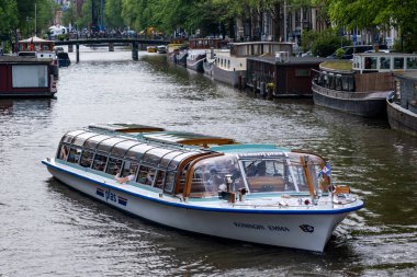 Amsterdam, Hollanda - 21 Haziran 2022: Kanalda seyahat teknesi
