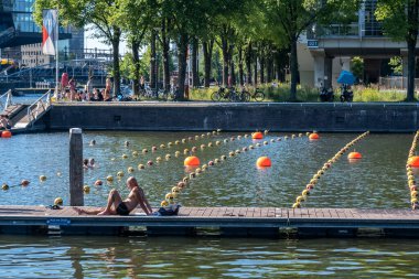 Amsterdam, Hollanda - 22 Haziran 2022: Marineterrein 'in iç limanında yıkanan insanlar