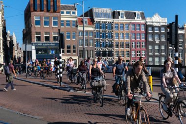 Amsterdam, Netherlands - 22 June 2022: People riding bikes on Damrak street