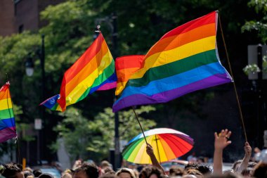 Montreal, CA - 7 August 2022: Gay rainbow flags waving above blurred crowd
