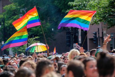 Montreal, CA - 7 August 2022: Gay rainbow flags waving above blurred crowd