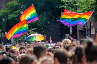 Montreal, CA - 7 August 2022: Gay rainbow flags waving above blurred crowd