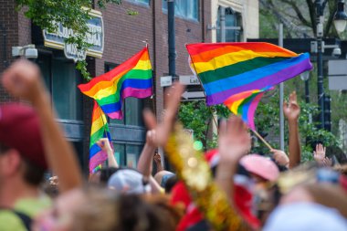 Montreal, CA - 7 August 2022: Gay rainbow flags waving above blurred crowd