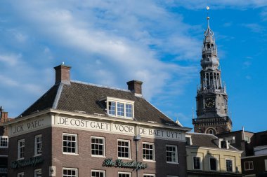 Amsterdam, The Netherlands - 21 June 2022: Grand Caf & Steakhouse The Grasshopper, at Damrak and Oudebrugsteeg, with The Oude Church in background
