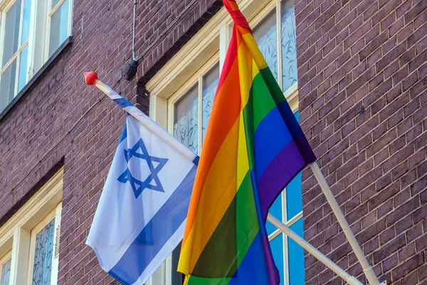 Israel flag and gay rainbow flag on poles