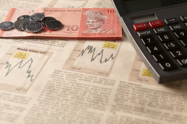 Tidningen börsen med miniräknare och pengar — Stockfoto