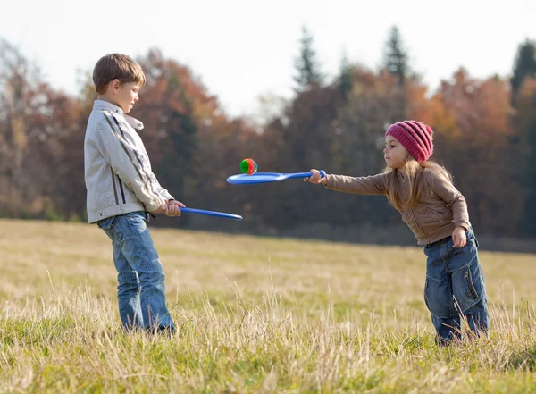 Kids playing tennis outside — Stock Photo, Image