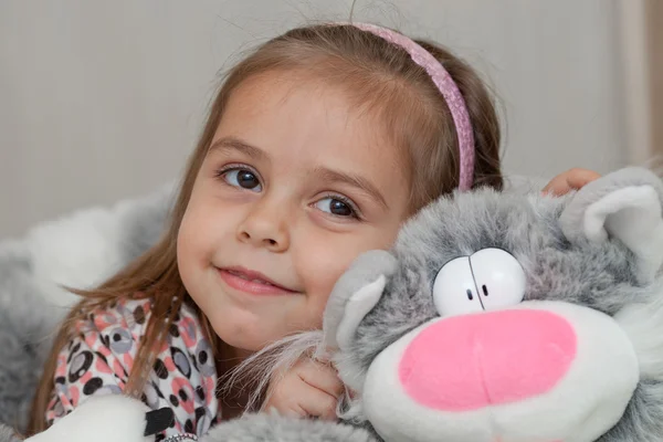 Menina com gato brinquedo macio — Fotografia de Stock