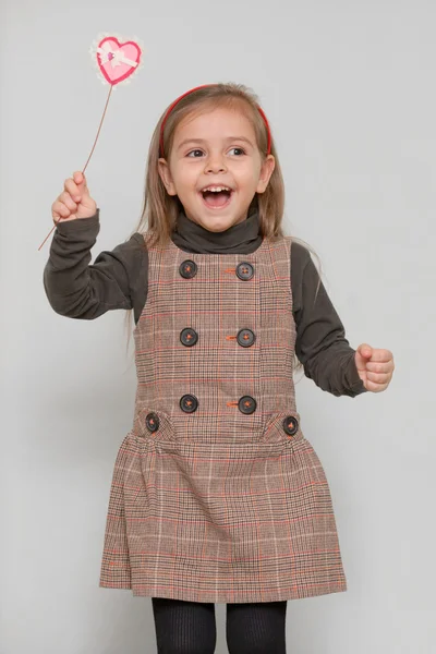 Cute little girl holding heart shape — Stock Photo, Image