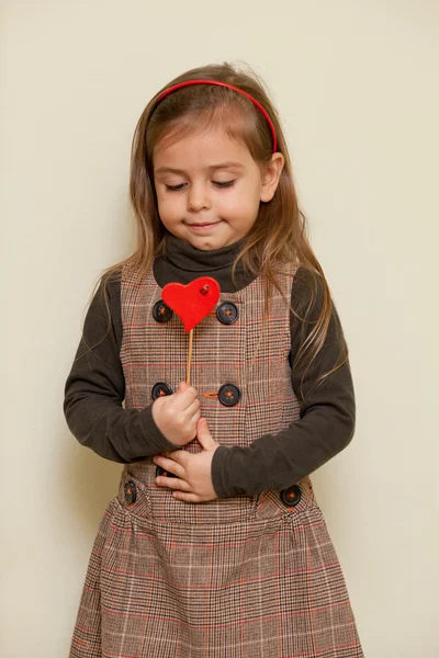 Cute little girl holding heart shape — Stock Photo, Image