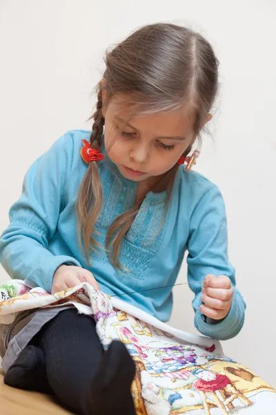 Kleines Mädchen stickt — Stockfoto