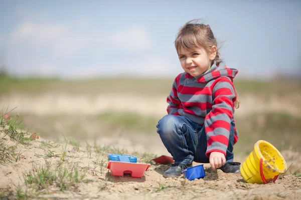 Malá dívka si hraje s pískem — Stock fotografie