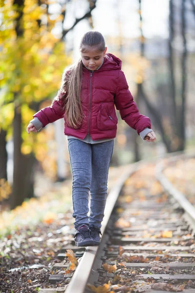 Menina andando para baixo trilhos de trem — Fotografia de Stock