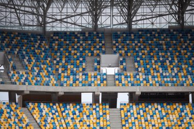 Tiered seats sit empty in large sports stadium