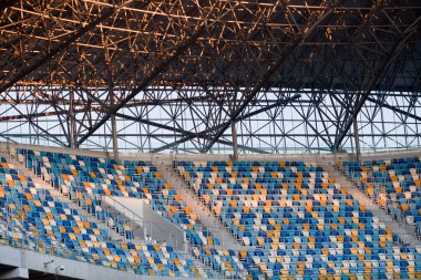 Tiered seats sit empty in large sports stadium