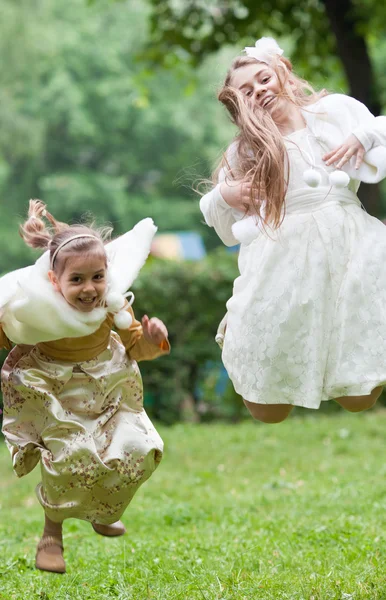 Two little beautiful girls jumping in a park — Stock Photo, Image