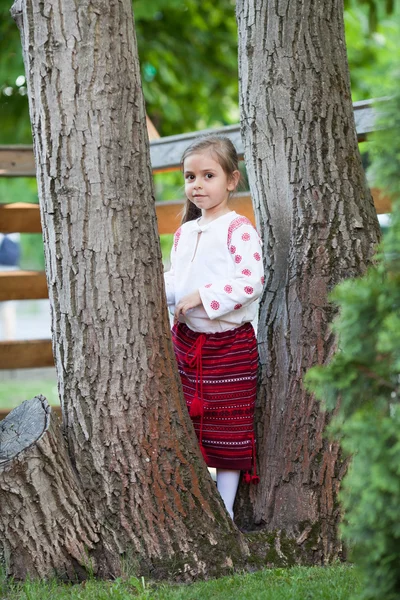 Schattig klein meisje tussen de bomen — Stockfoto