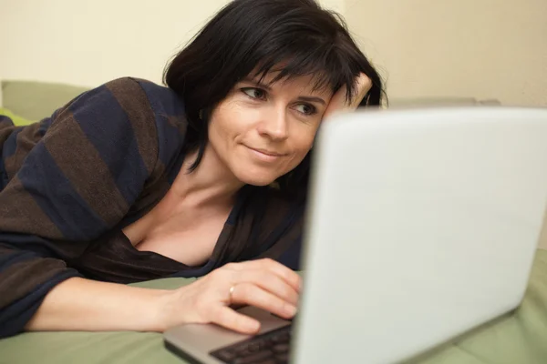 Woman with laptop on sofa — Stock Photo, Image