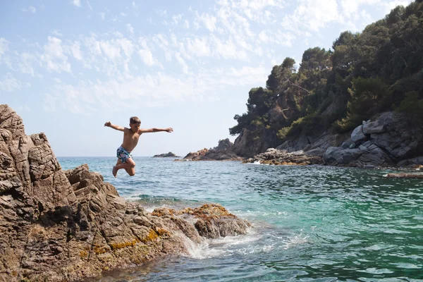 Jeune garçon sautant dans la mer — Photo