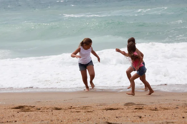 Trois enfants courent à la plage — Photo