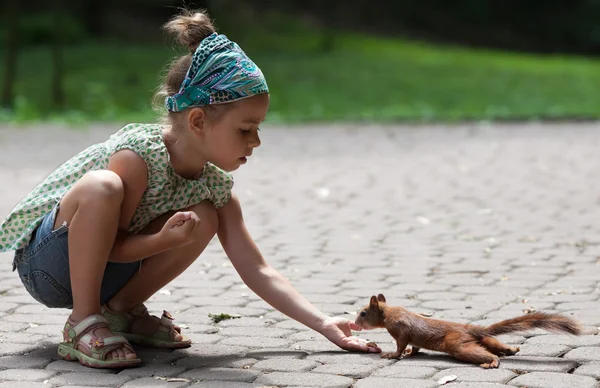 Little girl and squirrel — Stock Photo, Image