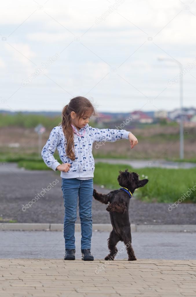 Little girl training a dog Stock Photo by ©waldru 49455397