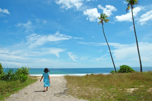 A girl running to a tropical beach — Stock Photo, Image
