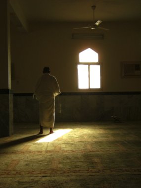 A muslim prays in one of the mosques in Saudi Arabia. clipart