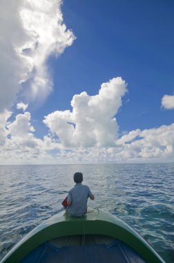 kimliği belirsiz bir yerel genç bir tekne oturur