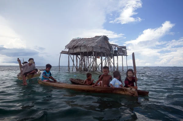 SEMPORNA, MALAYSIA - JULY 3 : A group of local sea gypsy kids paddle their boat — Stock Photo, Image
