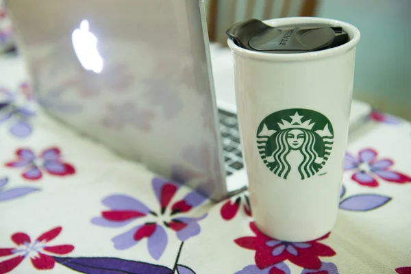 uzun boylu starbucks kahve önünde diz üstü bilgisayar.
