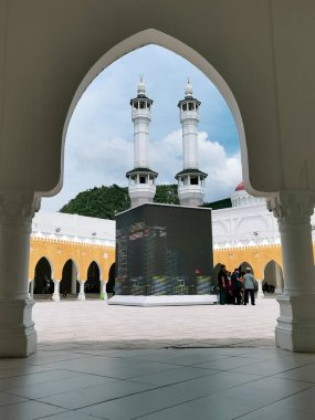 GUA MUSANG, KELANTAN, MALAYSIA-CIRCA HAZİRAN 2022: Kelantan 'daki Gua Musang' daki Mescid Razaleigh 'de Müslüman turistler. Cami, Mekke, Suudi Arabistan 'daki Mescid-i Haram' dan esinlenilmiştir..