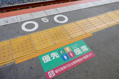 KOBE, JAPONYA-CIRCA 2018: Öncelikli oturma tabelaları KOBE, Japonya 'da bir tren istasyonunun zemininde basıldı.