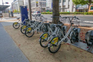 KOBE-JAPONYA-CIRCA 2018: Japonya 'nın Kobe kentindeki kaldırımda bisiklet kiralama istasyonu.