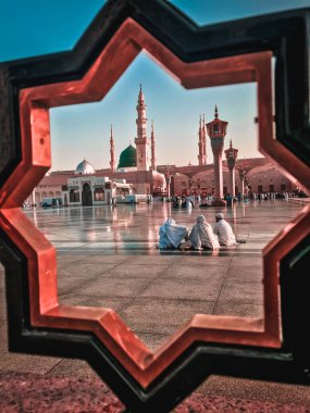 AL MADINAH, SAUDI ARABIA-CIRCA 2019: Pilgrimler Nabawi Camii 'nin bileşiğinde dinleniyor. Kapalı pastel renk filtresi uygulandı.