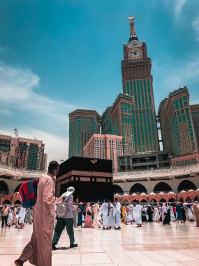 MECCA, SAUDI ARABIA-CIRCA 2019: Abraj Al Yem (Royal Clock Tower Makkah) Makkah, Suudi Arabistan 'da iken Müslüman hacıların dolaşım (tawaf) Kaabaab. Sessiz pastel renk filtresi uygulandı..