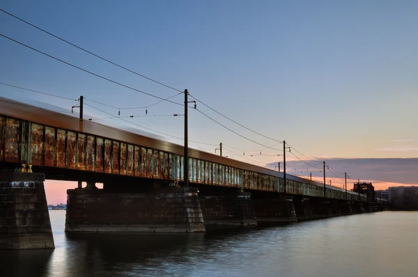 Jedoucí nákladní vlak na rezavou most — Stock fotografie