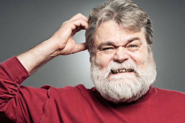 Зрелый белый мужчина царапает голову, как будто что-то забыл.
